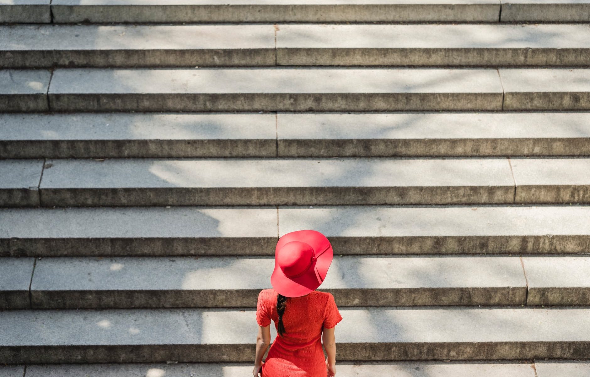 woman in red dress climbing the stairs